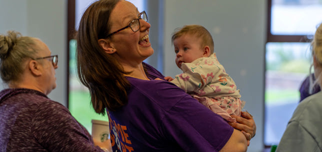 Home-Start staff member holding a baby
